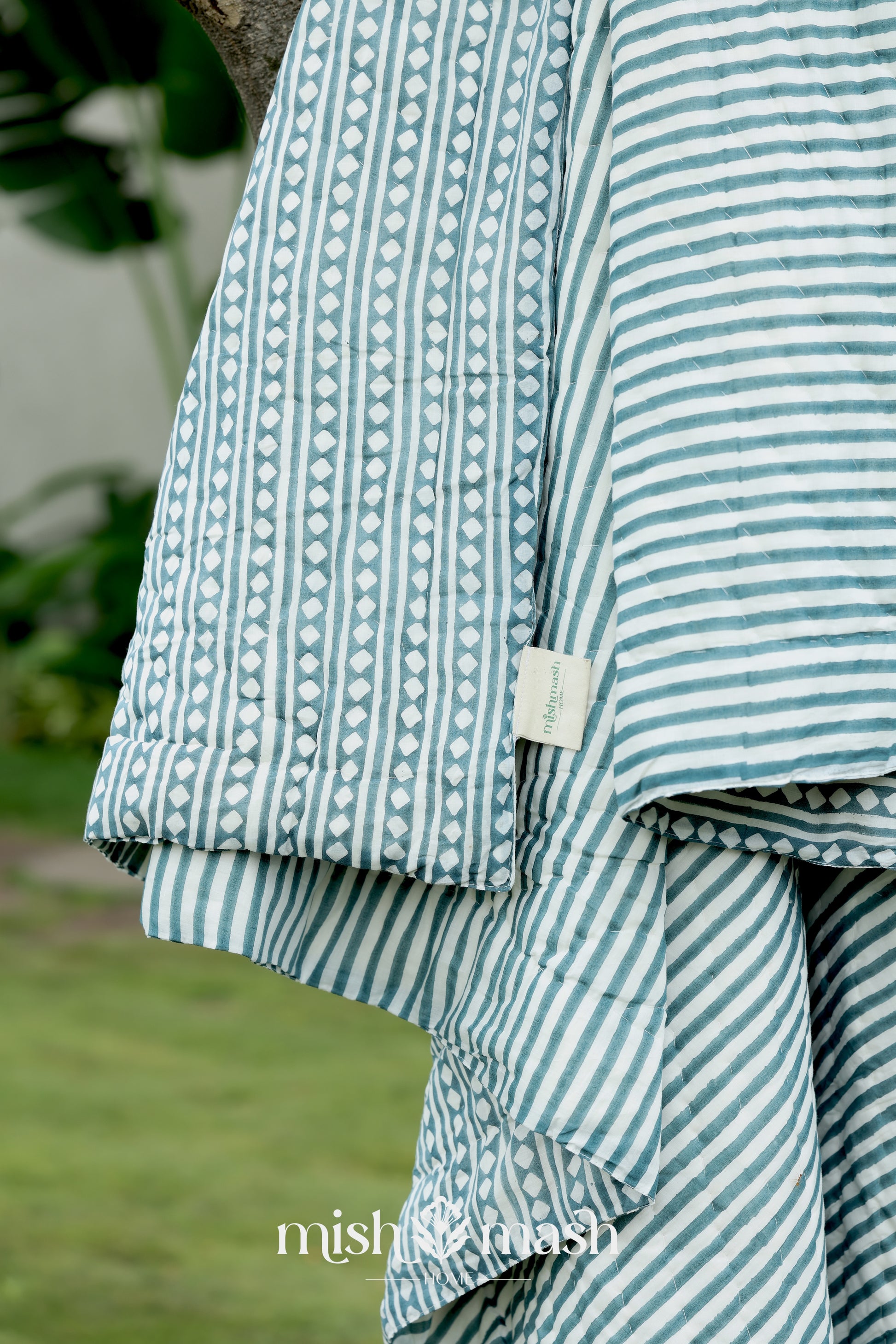 Close-up of a blue and white striped reversible jaipuri quilt