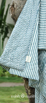 Striped jaipuri quits with a visible brand logo against a natural background. jaipuri razai.