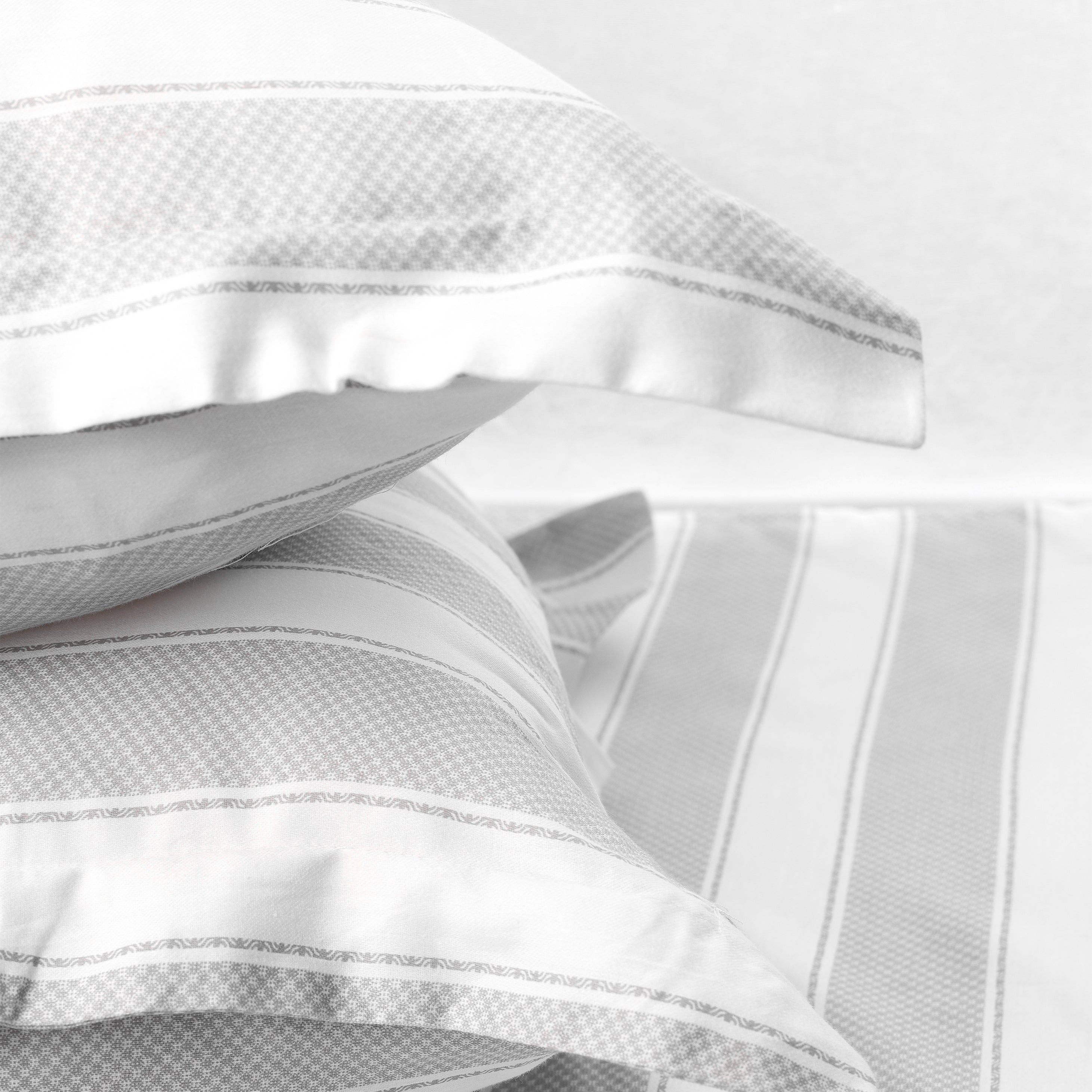 Stack of two white and grey pilows with pure cotton 400 tc double bed bedsheet in king size