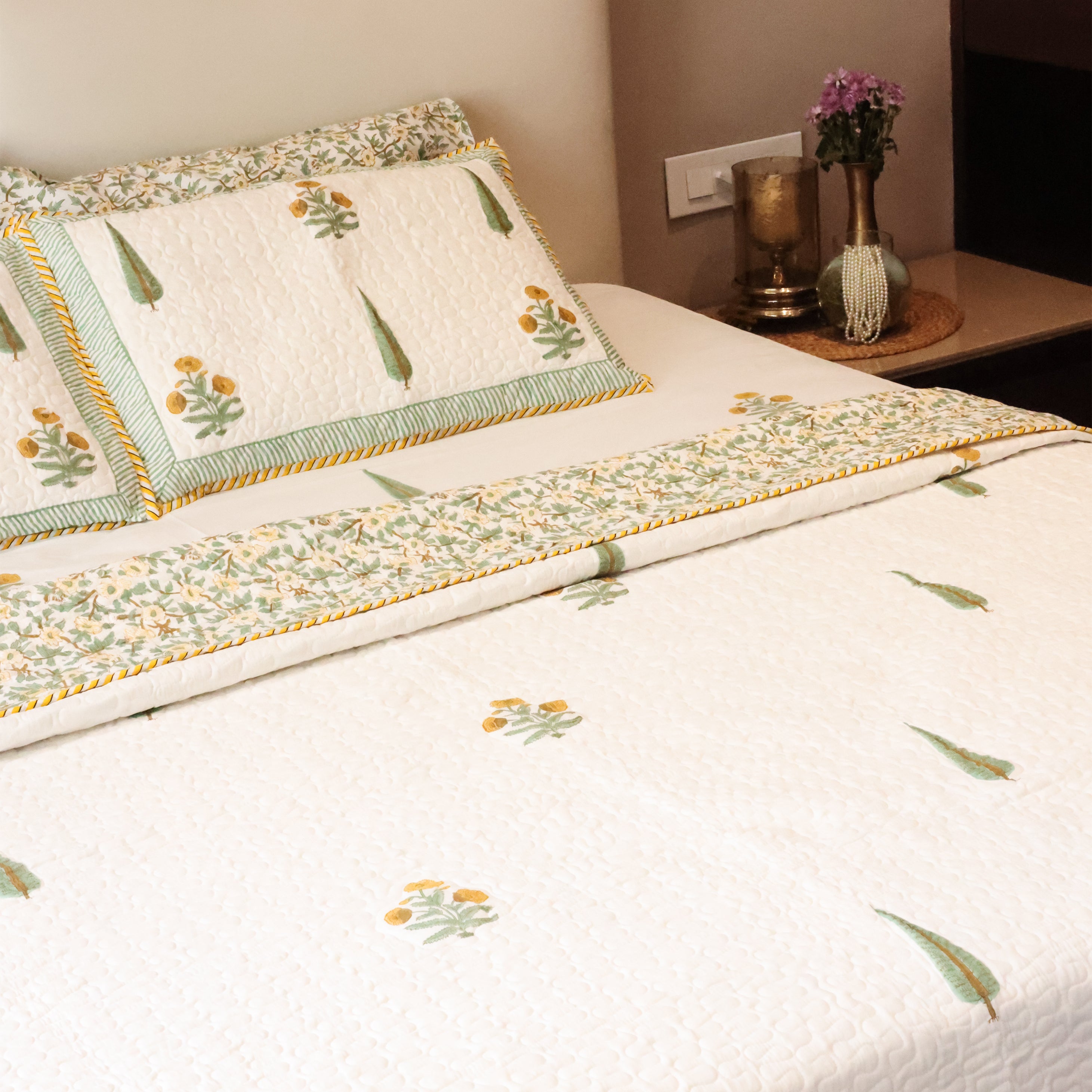 Bed with floral cotton bed cover and cotton pillows in a bedroom setting. bedspreads that make the perfect wedding gift.