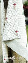 White quilt with floral blockprint on a wooden tree outdoors. Jaipuri razai.