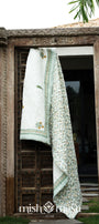 Decorative jaipuri quilt with yellow and green patterns hanging on a wooden door. Buy jaipuri quilts online.