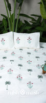 Floral printed cotton bed cover with matching cotton pillows, set against a natural background. Buy luxury bedspread.