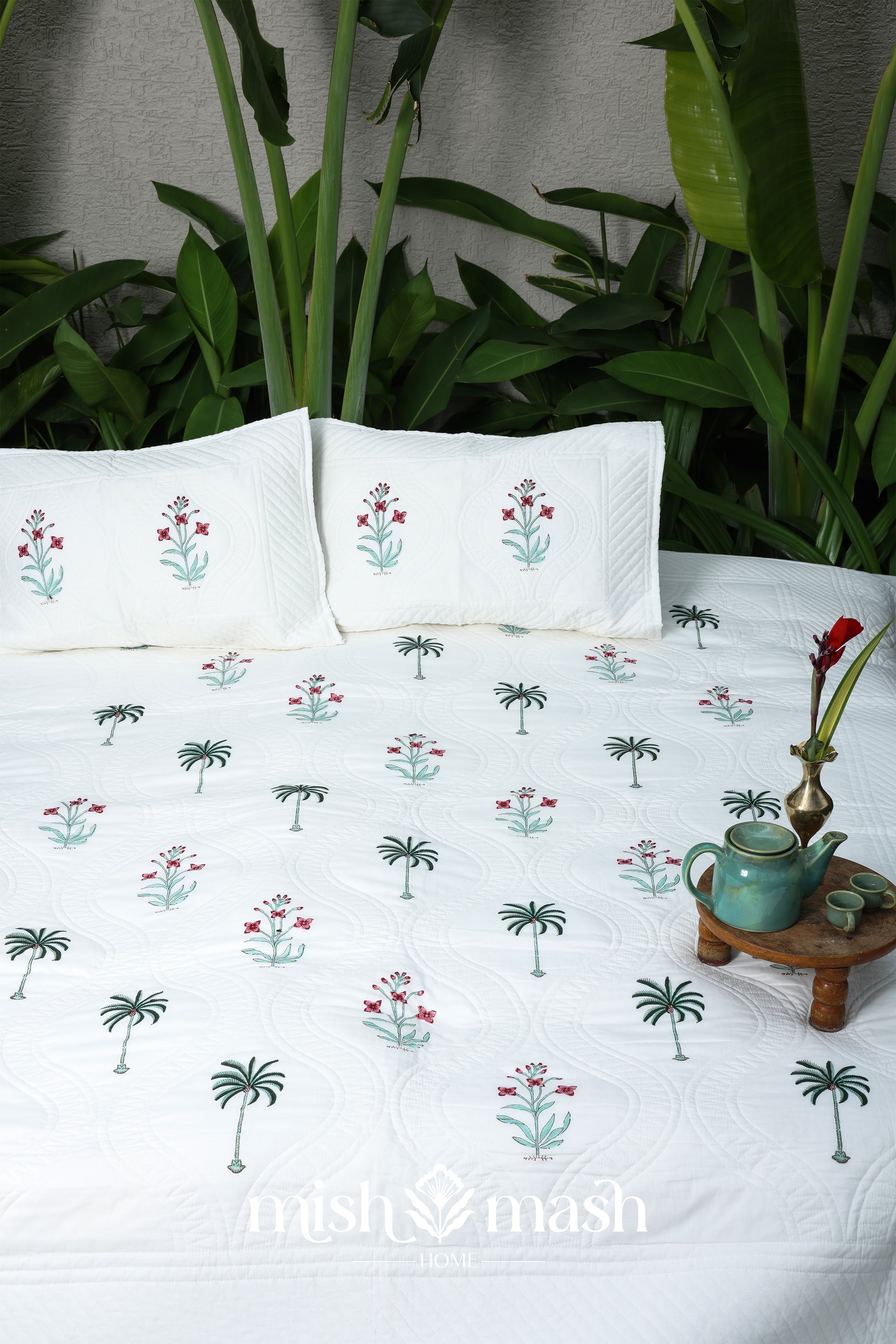 Floral printed cotton bed cover with matching cotton pillows, set against a natural background. Buy luxury bedspread.