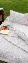 Outdoor setting with a bed covered in striped double bed sheet and pure cotton pillows.
