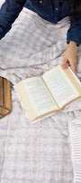 Person reading a book on a bed while using a cozy reversible red and white cotton dohar blanket