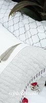 Close-up of a white cotton pillow of a cotton bed cover with floral print and  brand name: Mishmash.