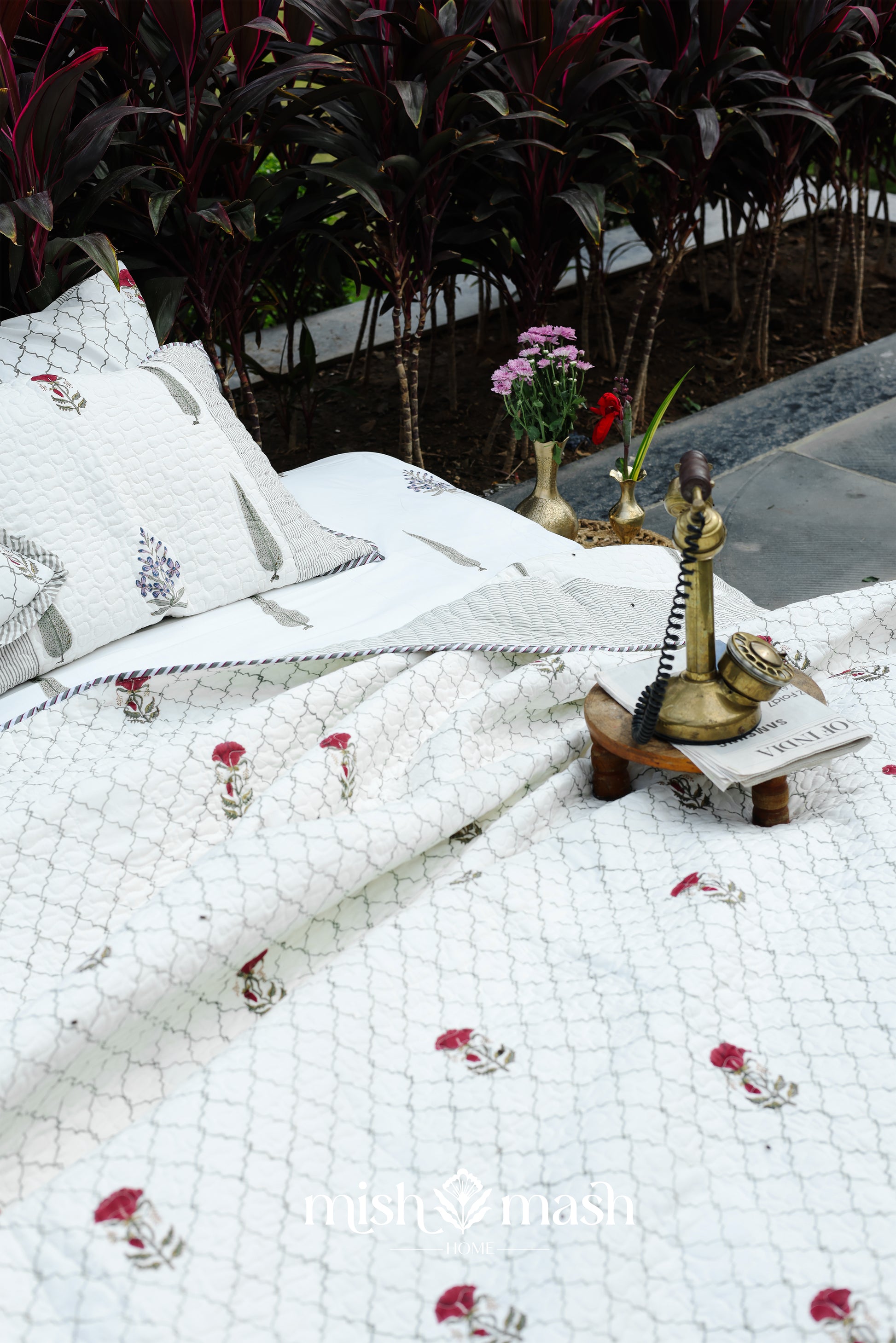 White cotton bedspread with floral patterns on top of a double bed sheet in cotton. Buy luxury bedspread online.