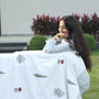 Woman wrapped in a white floral cotton dohar blanket with 'mish mash' branding in an outdoor setting. Cotton dohar.