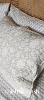 Matching cotton floral pillows on a bed with grey and white chevron print double bed sheet