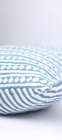 Cotton cushion cover with blue and white stripes on a light gray background. 