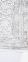 Luxury bed spread with intricate floral patterns in grey and white 