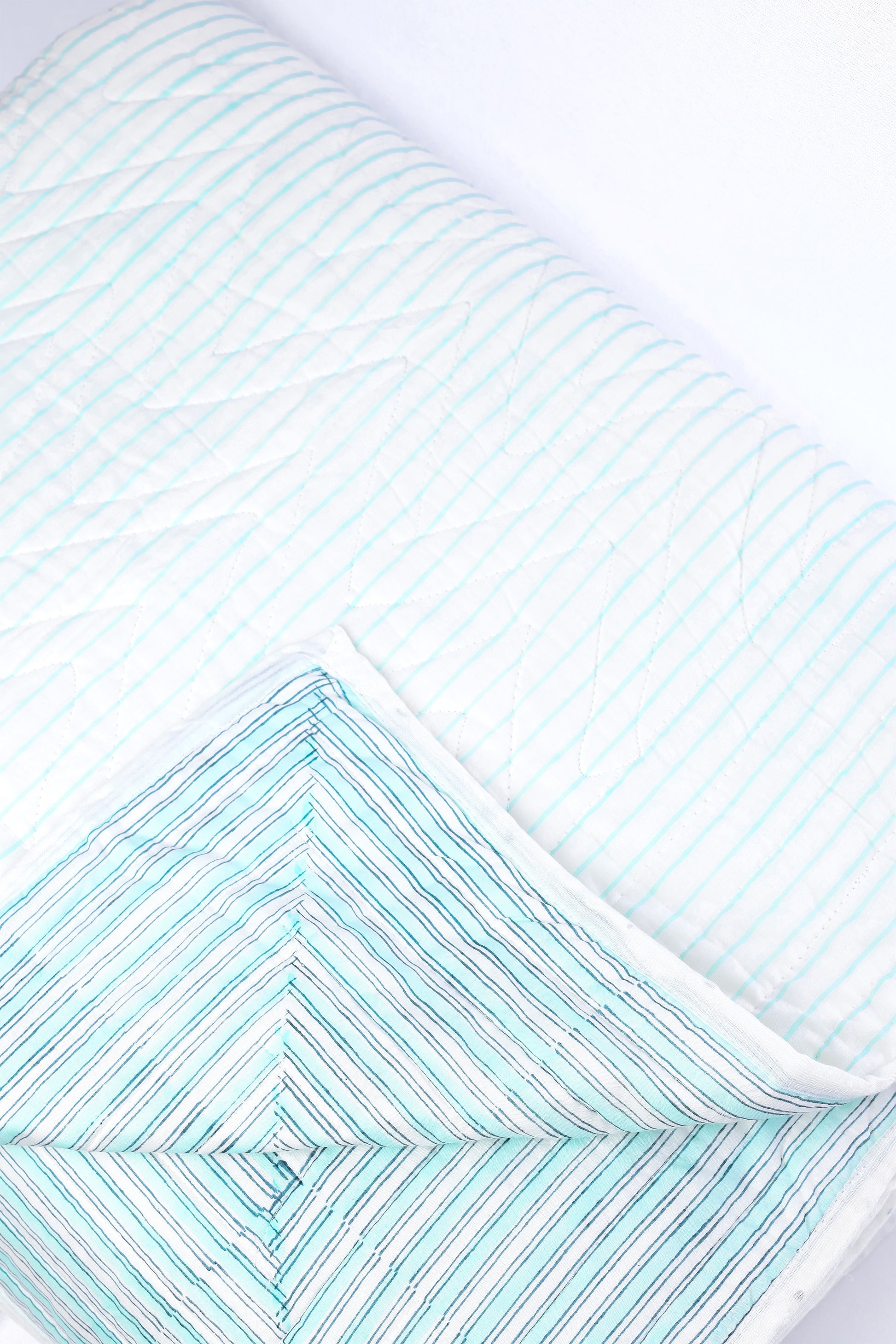 Close-up of a cotton dohar blanket with light blue and white stripes 