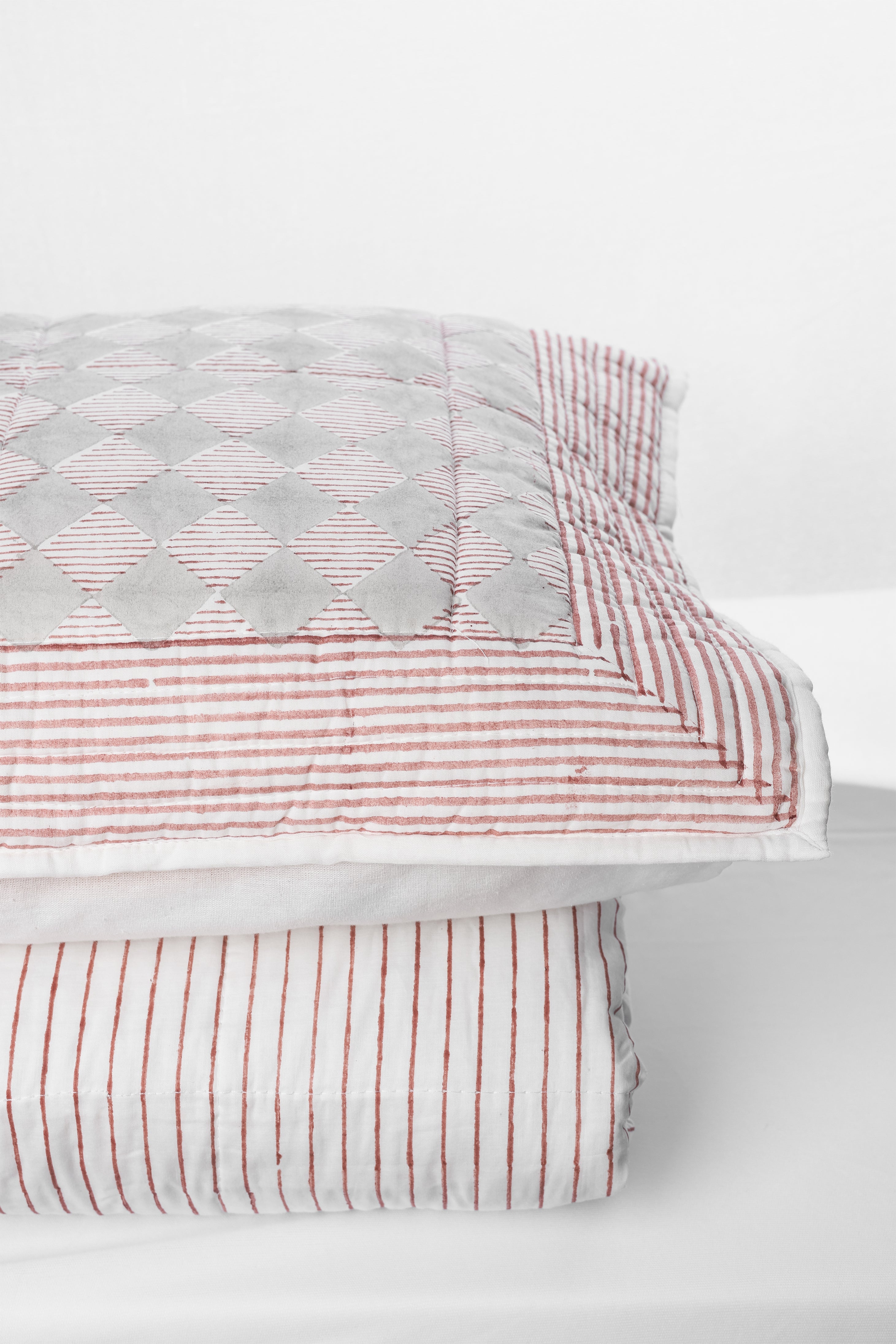 red and white vertical striped cotton bed spread with matching geometric cotton pillow cover 