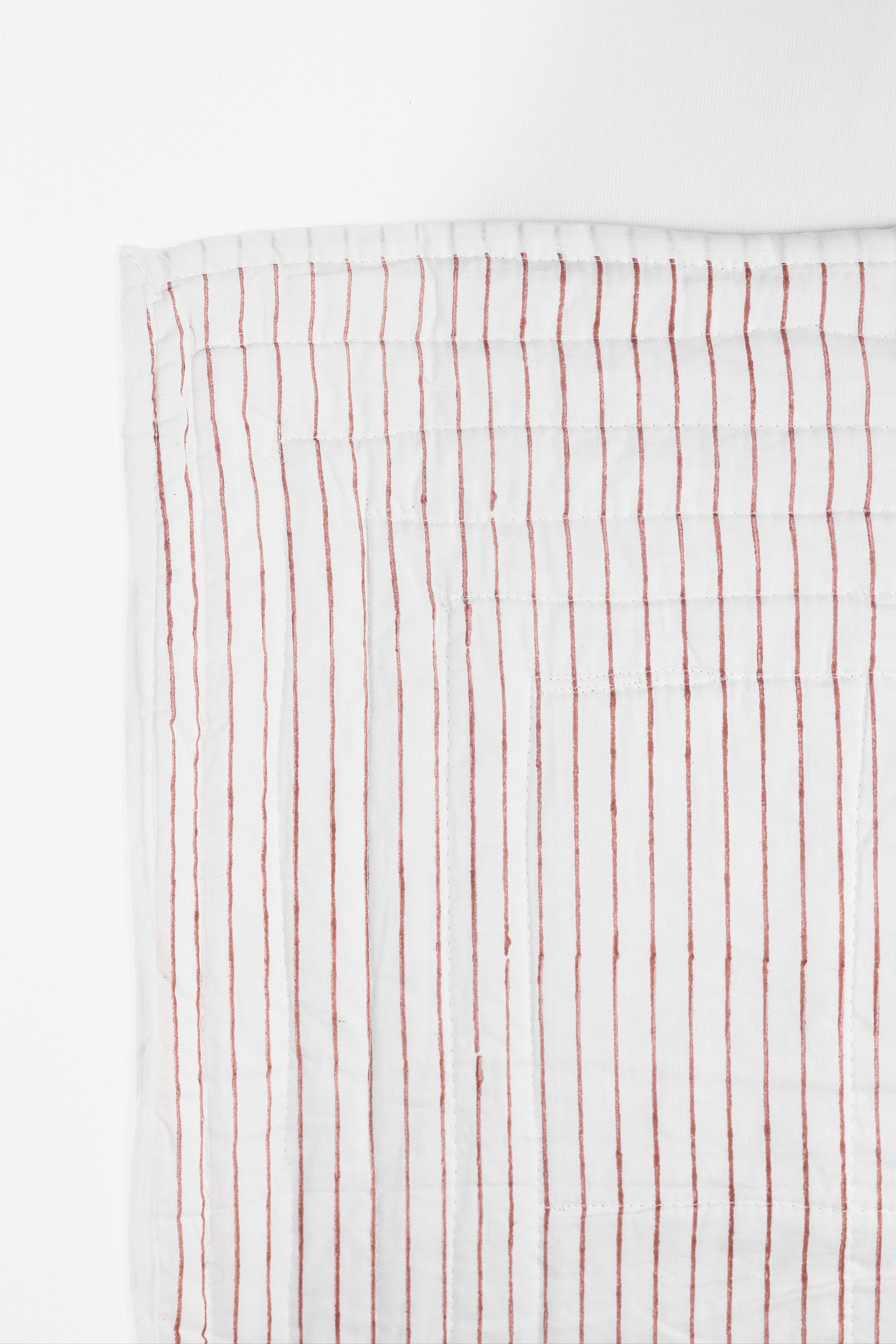 Reversible cotton bed spread with red vertical stripes on a white background on one side