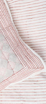 Close-up of a red and white striped quilted cotton bed spread with a  checkered pillow cover