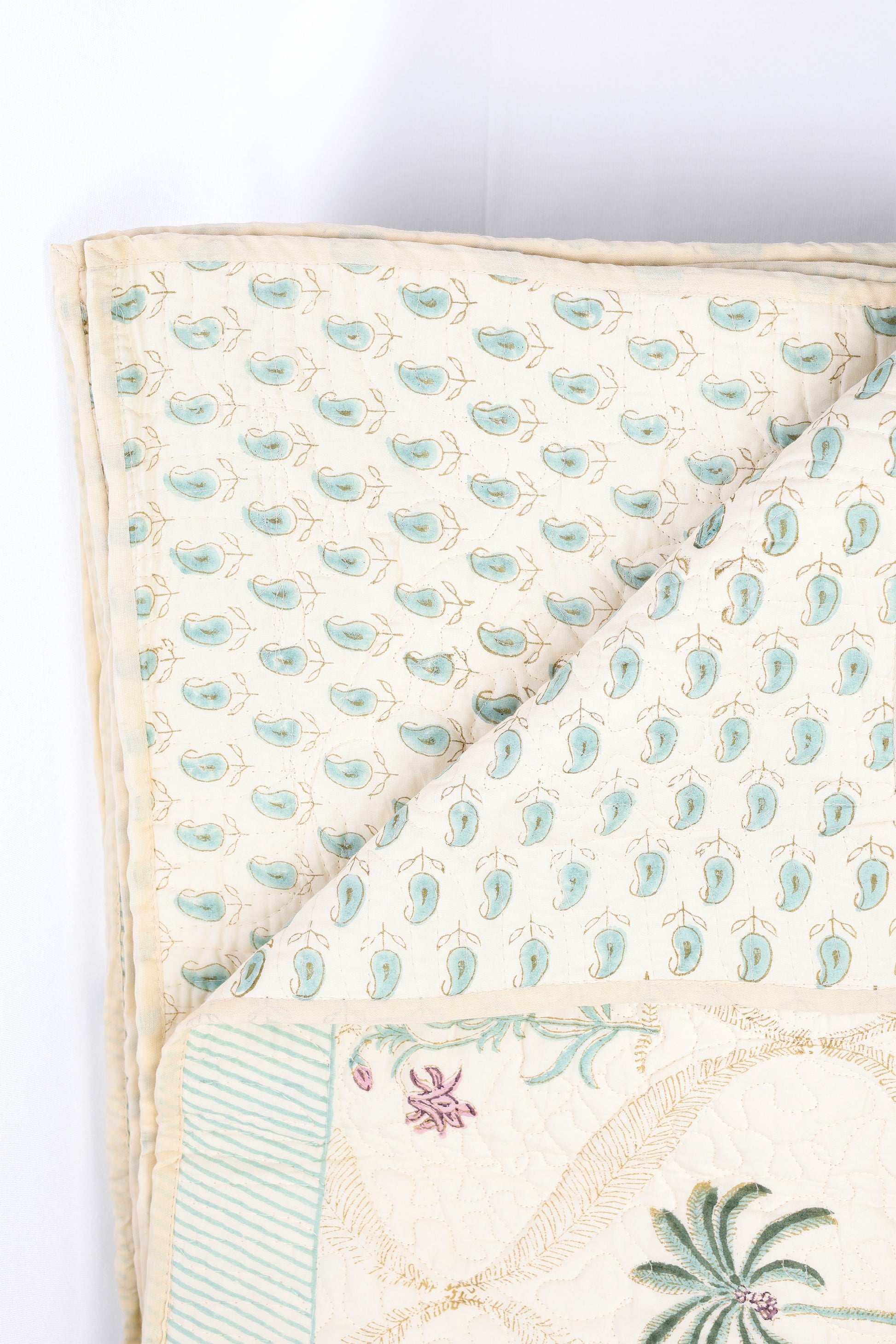Reversible quilted cotton luxury bed spread with green and pink paisley motifs and palm motifs on back side
