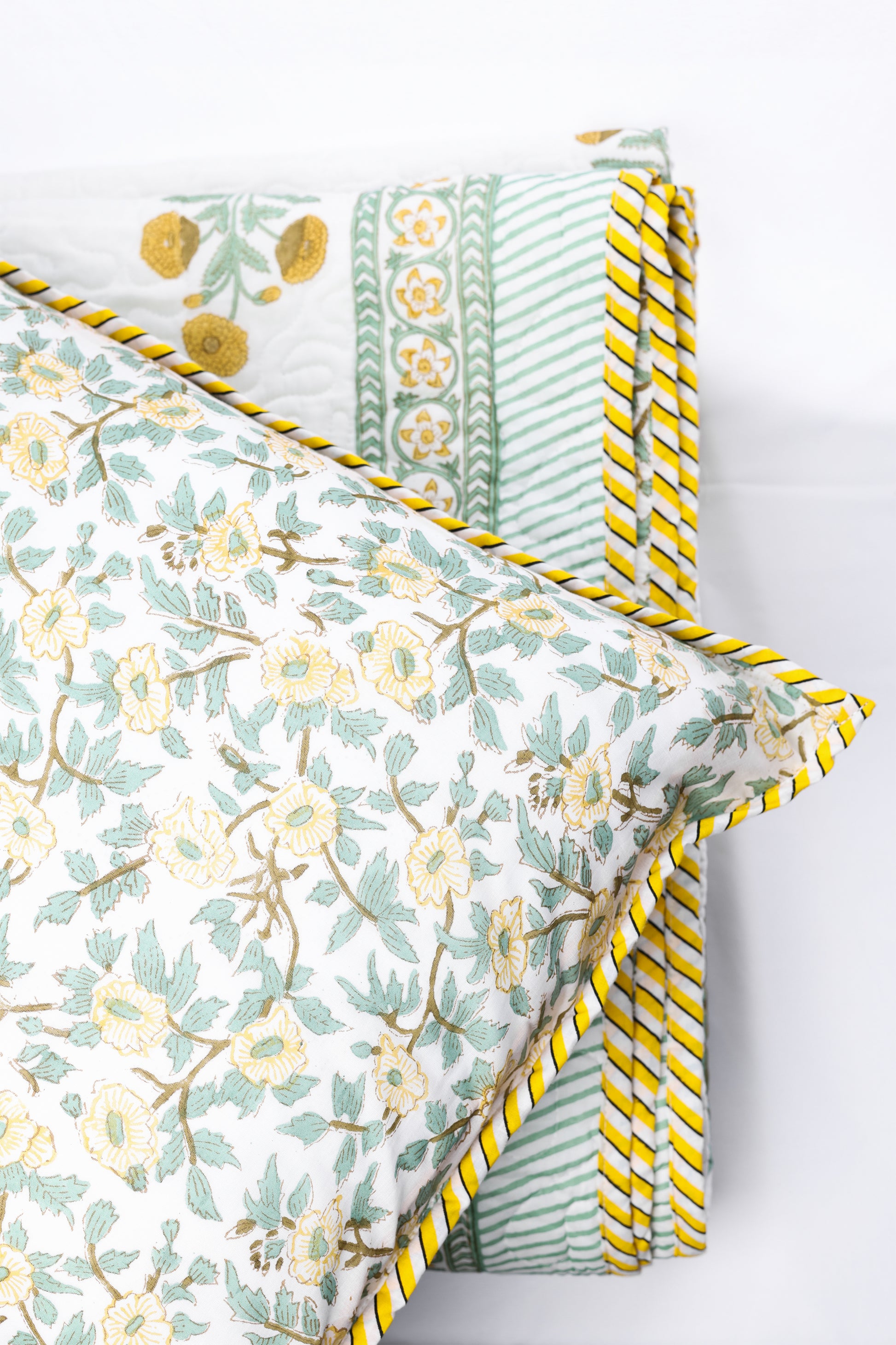 floral pillow with yellow cotton bed cover on a white background. buy good earth bedspread
