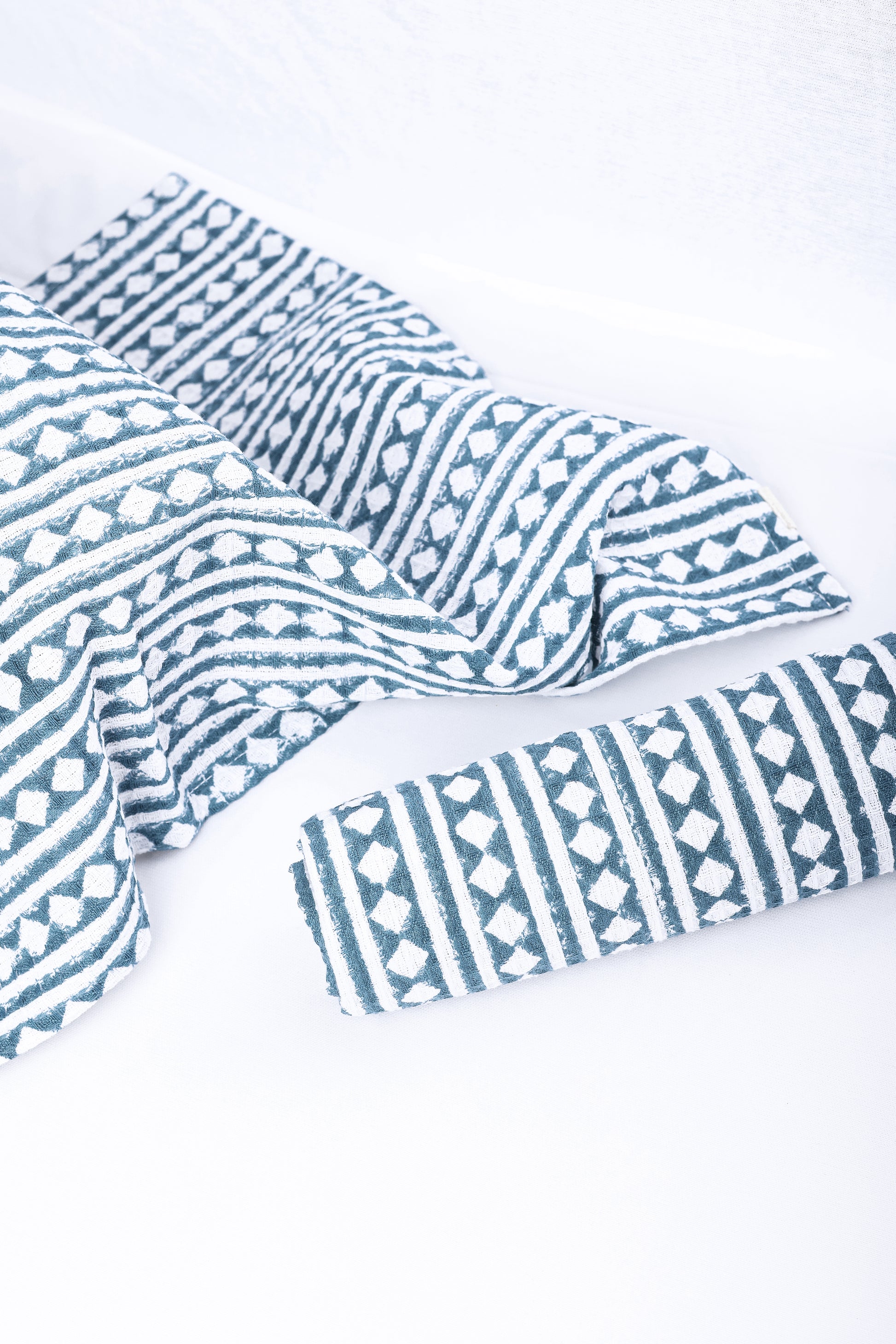 Waffle cotton hand towels with blue and white geometric pattern.