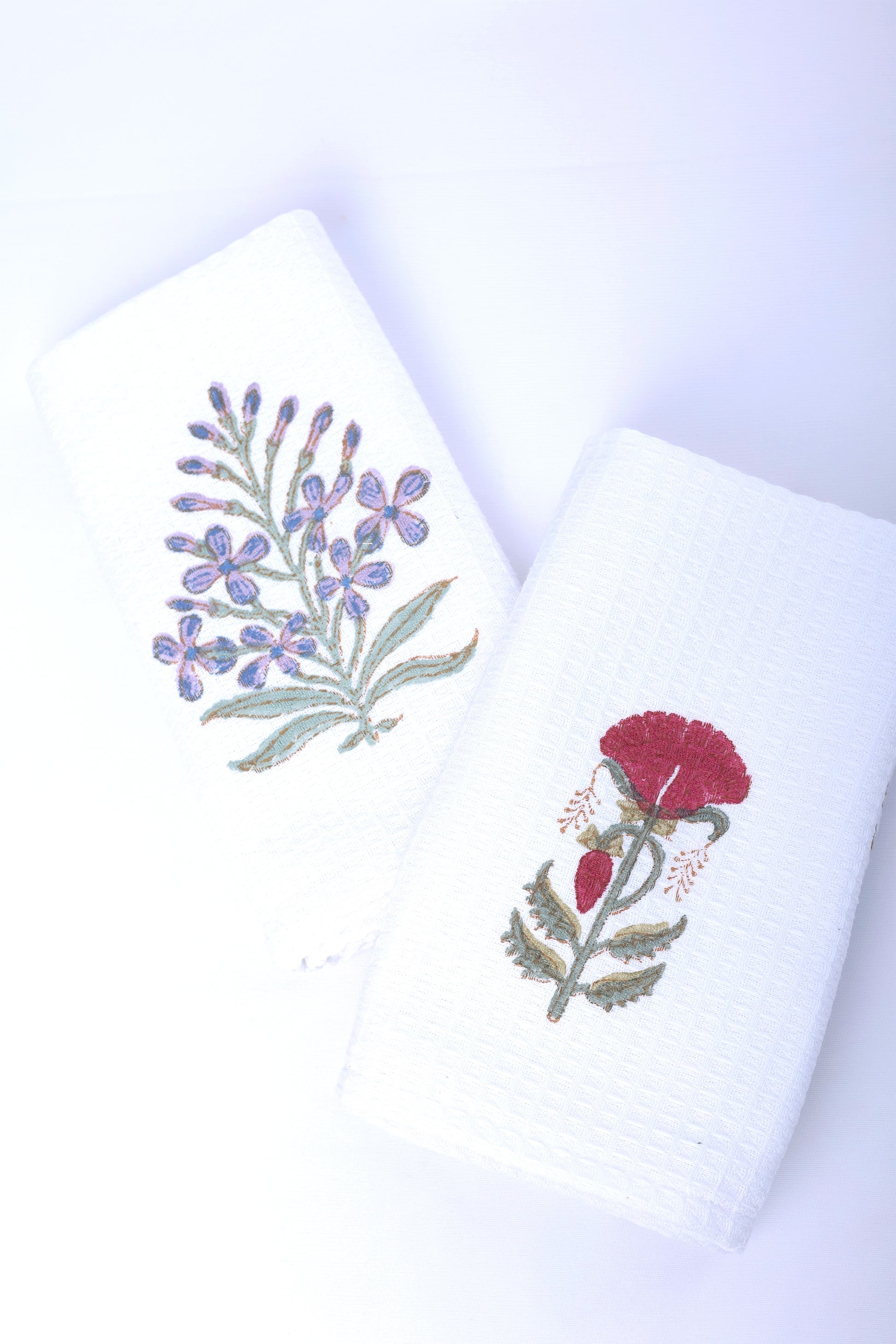 Two printed hand napkins with floral designs on a white background. Bath linen.