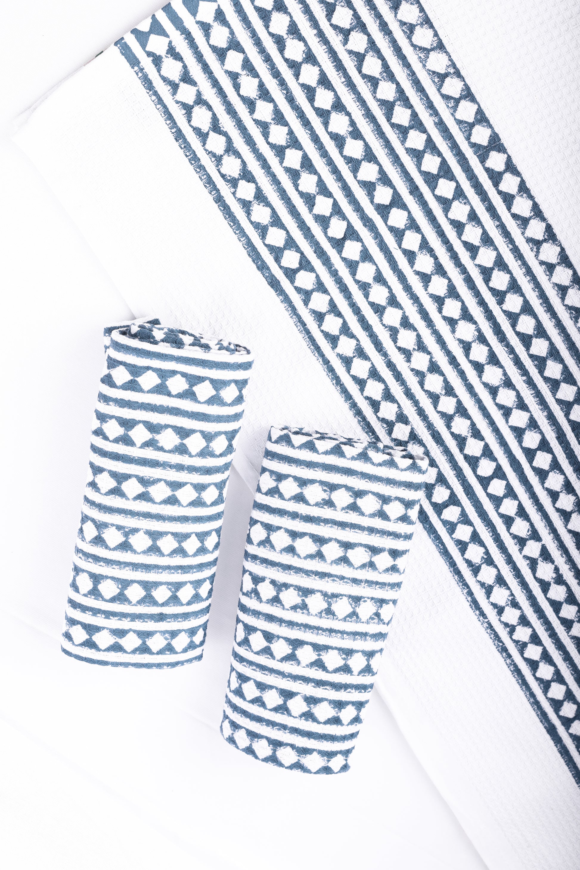 Blue and white patterned quick dry bath towel that and 2 folded hand towels. Trident towels.