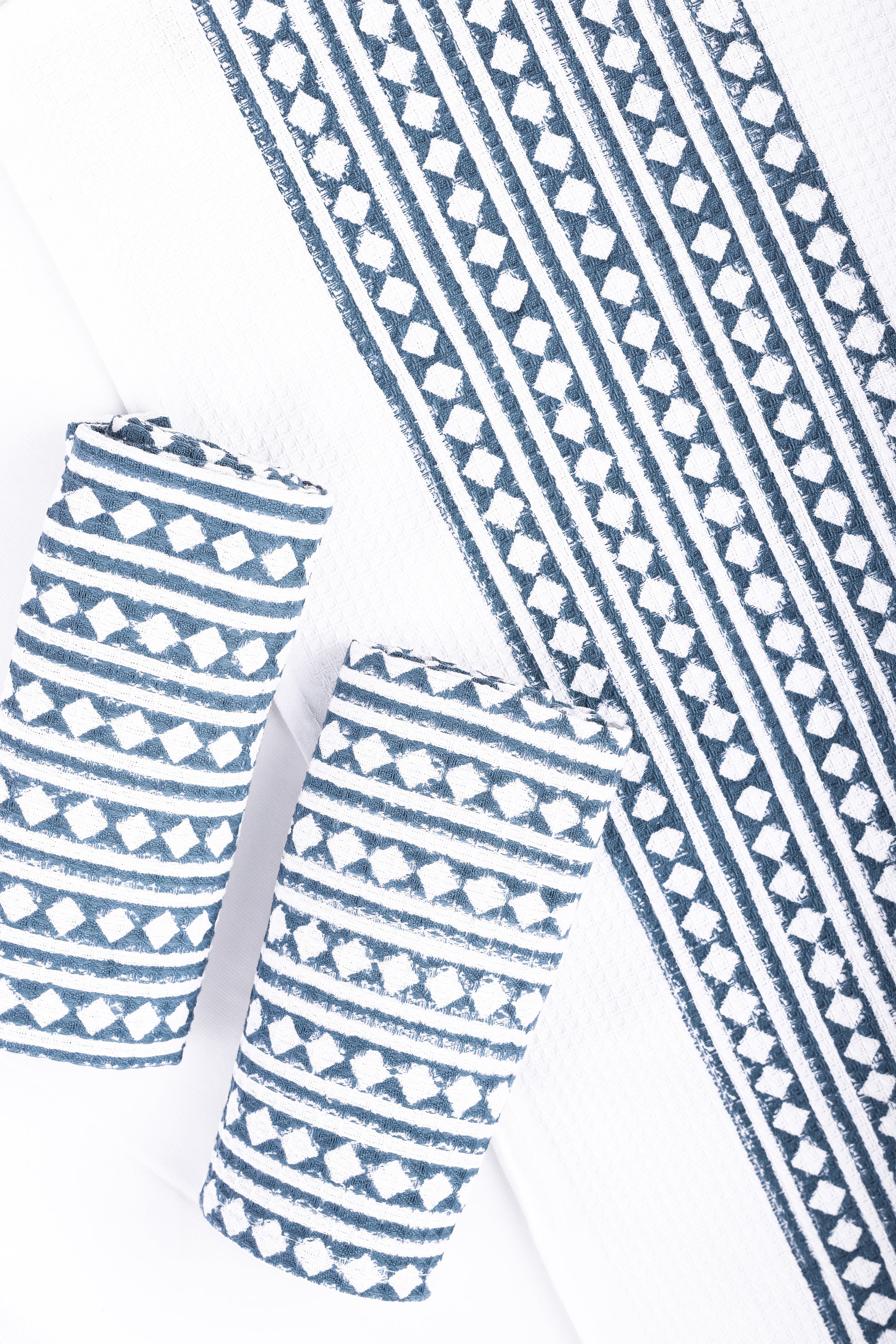 Blue and white hand block printed cotton bath towel with two hand towels on a white background