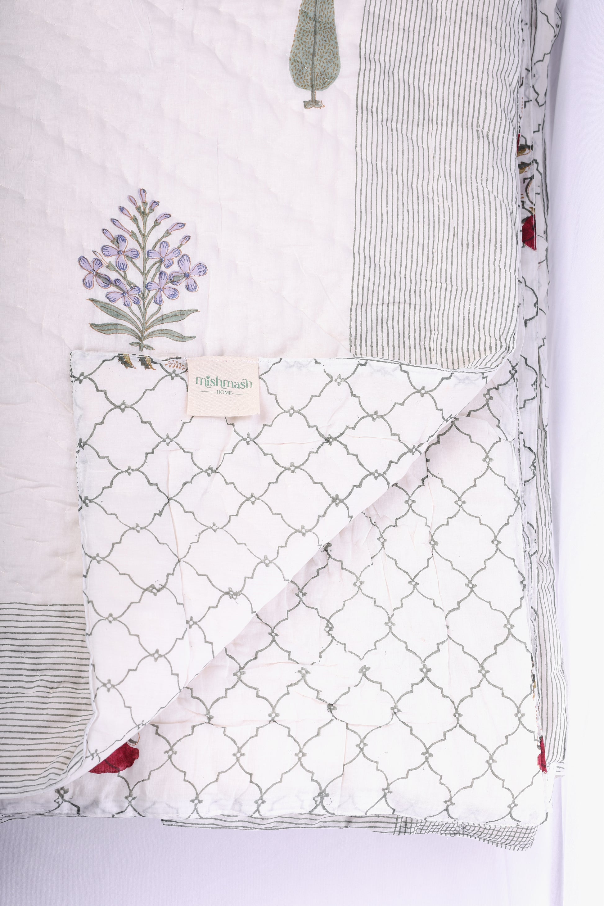 Reversible winter Quilt with block print floral illustration on a white background. Buy all seasons jaipur razai.
