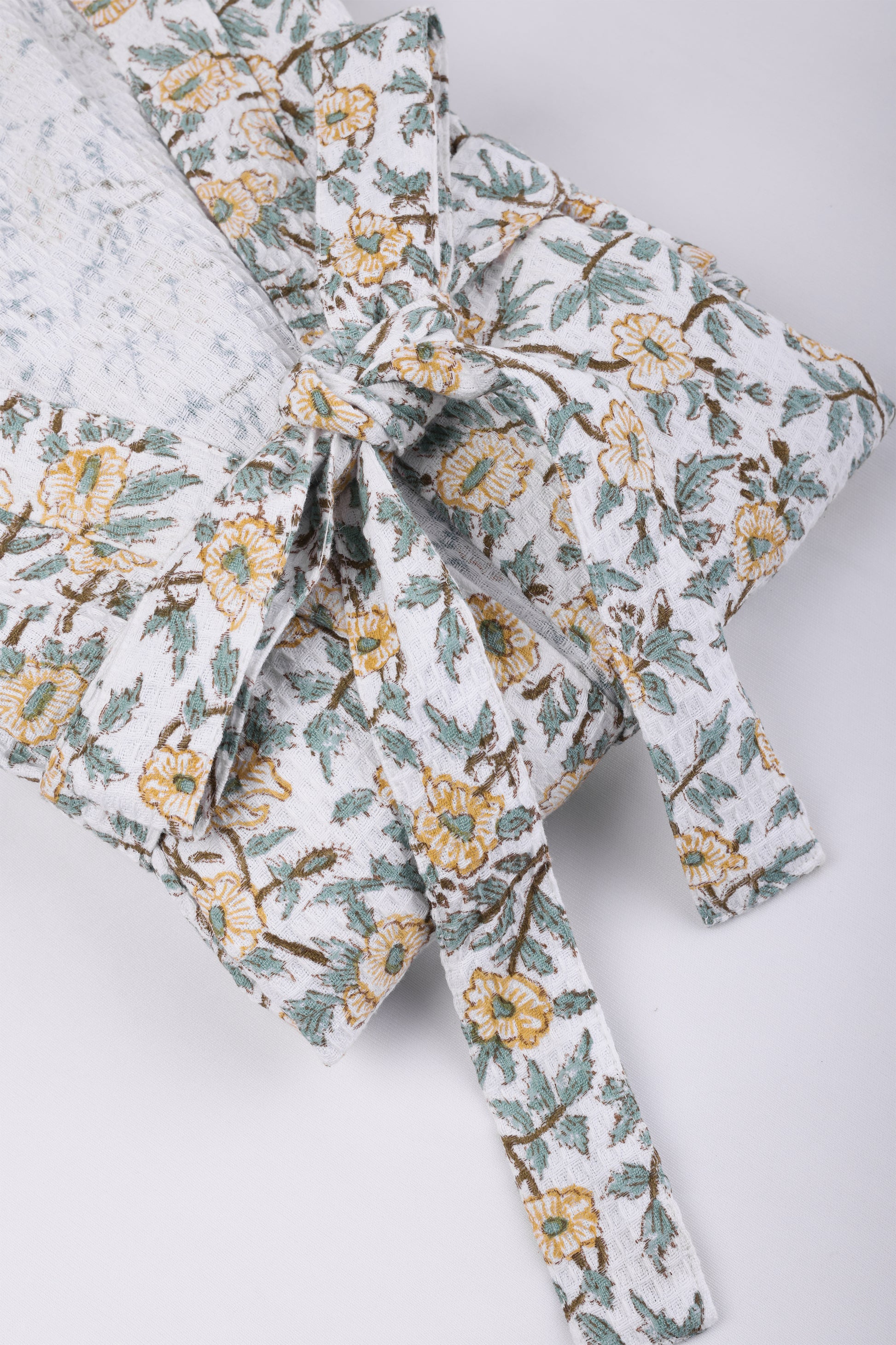 Floral-patterned bathrobes for women with a tie on a light gray background