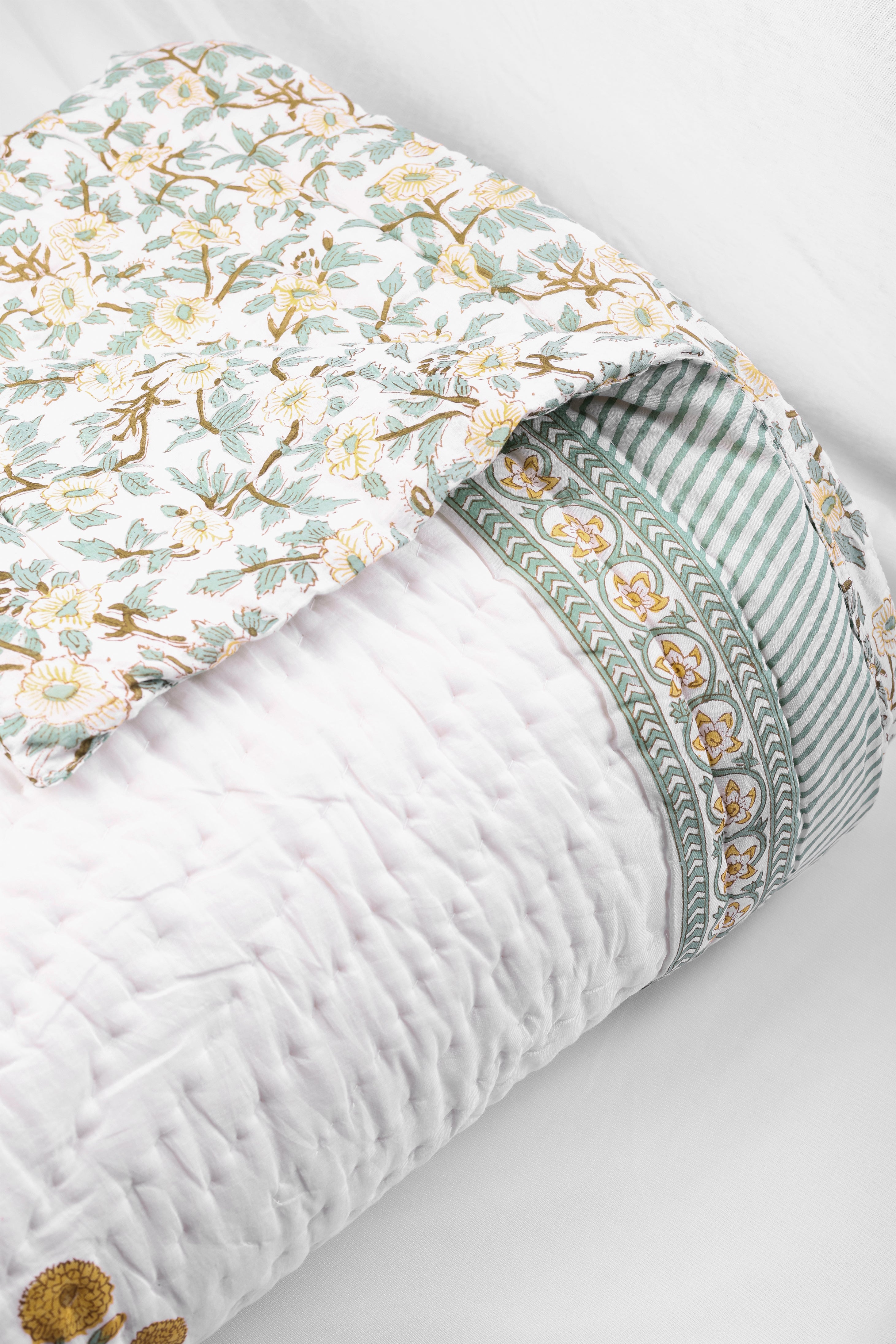 Floral AC quilt kept on a light gray background. reversible jaipur ac quilt online