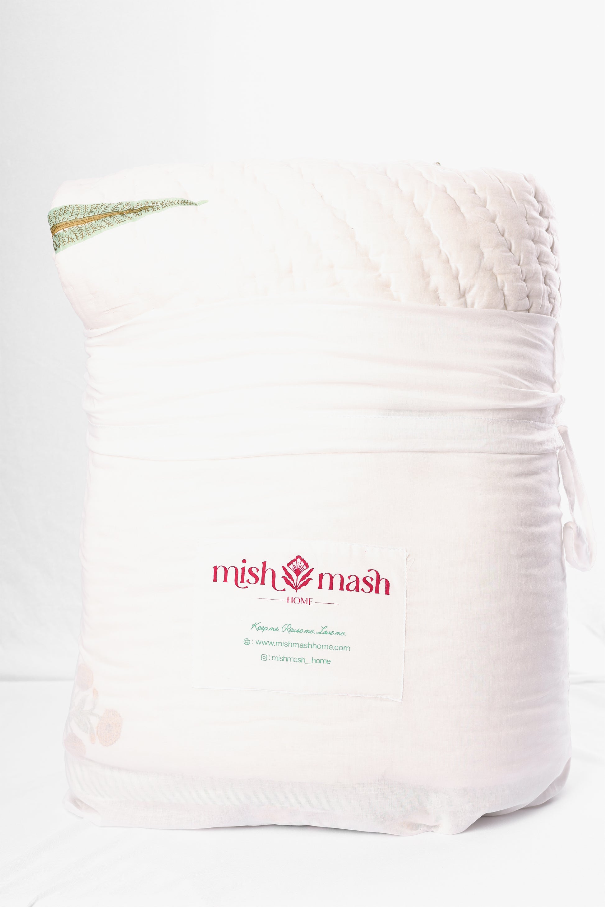 White cotton bag with 'mish mash' branding containing a jaipuri razai inside. buy razai online. jaipur rajai