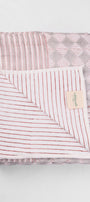 Folded reversible cotton dohar blanket with red striped pattern on a light gray background