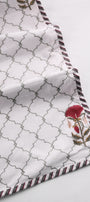 Cotton dohar blanket with geometric pattern and red floral designs on a white background. Buy summer blanket.