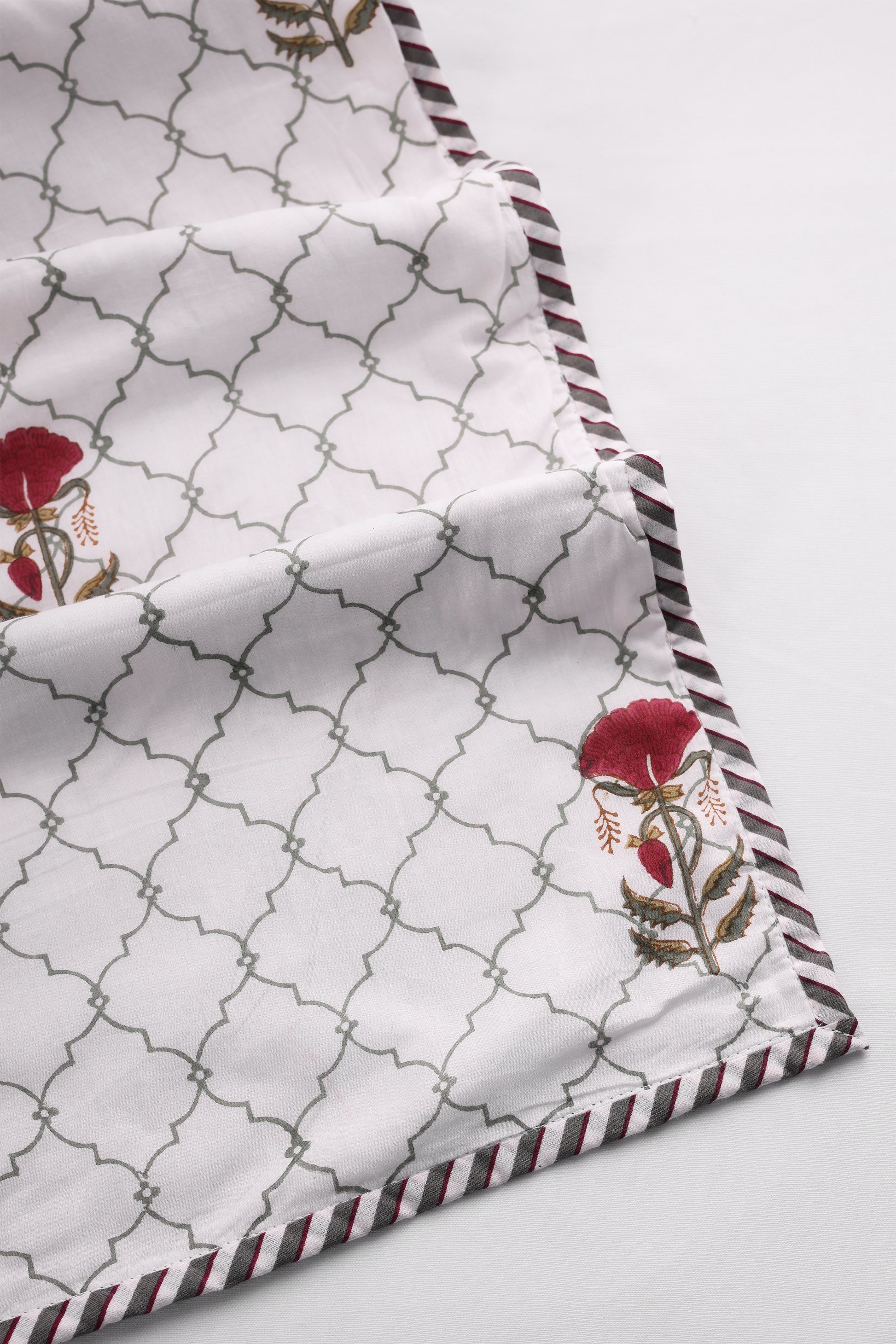 Cotton dohar blanket with geometric pattern and red floral designs on a white background. Buy summer blanket.
