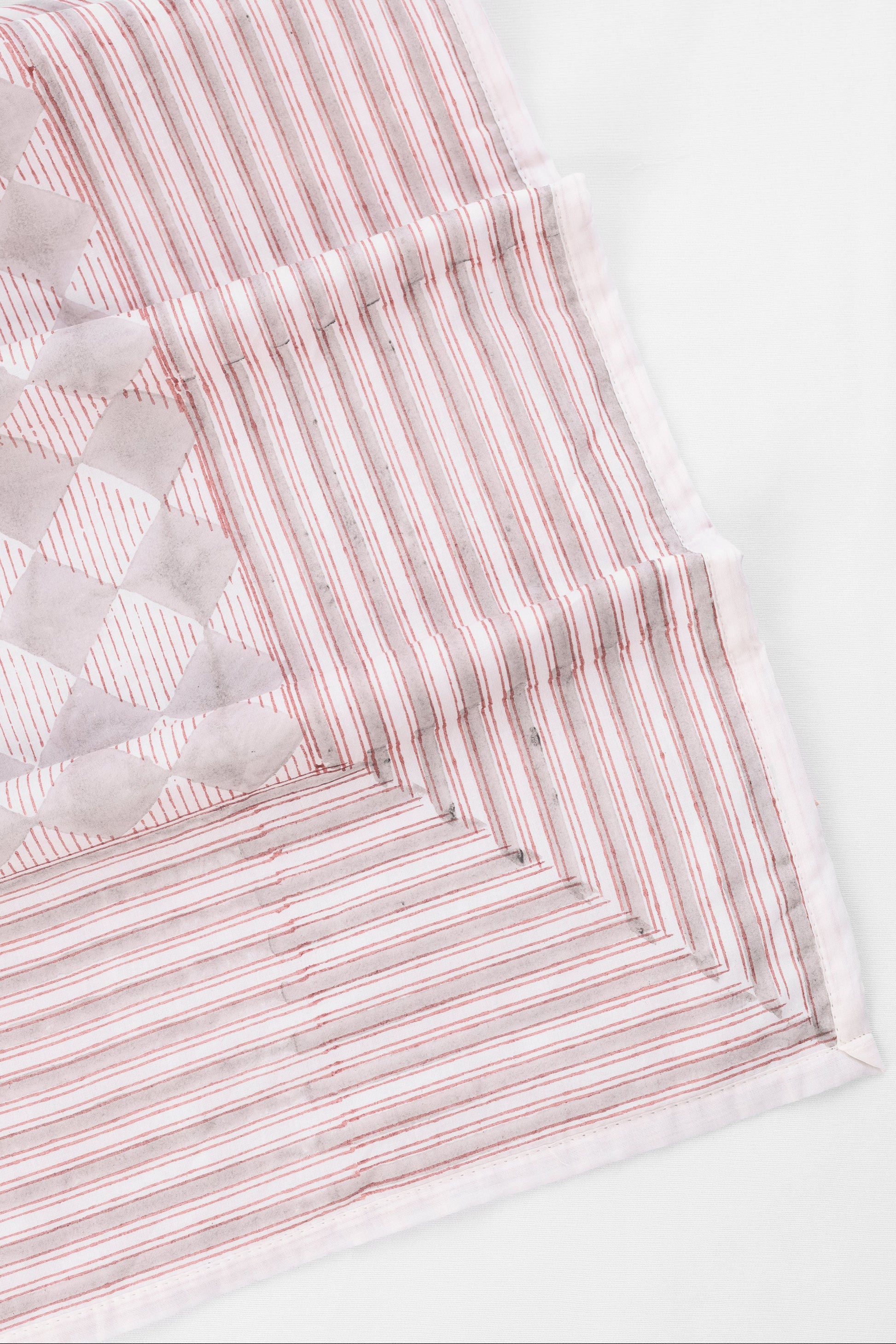 Reversible cotton dohar blanket with red and grey geometric pattern on white muslin cotton