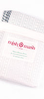 White cotton dohar blanket in a white cotton bad with 'mishmash' branding on a white background. buy dohar online.
