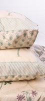 Stack of pure cotton pillows on a double bedsheet with a neutral background