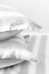 Stack of two white and grey pilows with pure cotton 400 tc double bed bedsheet in king size