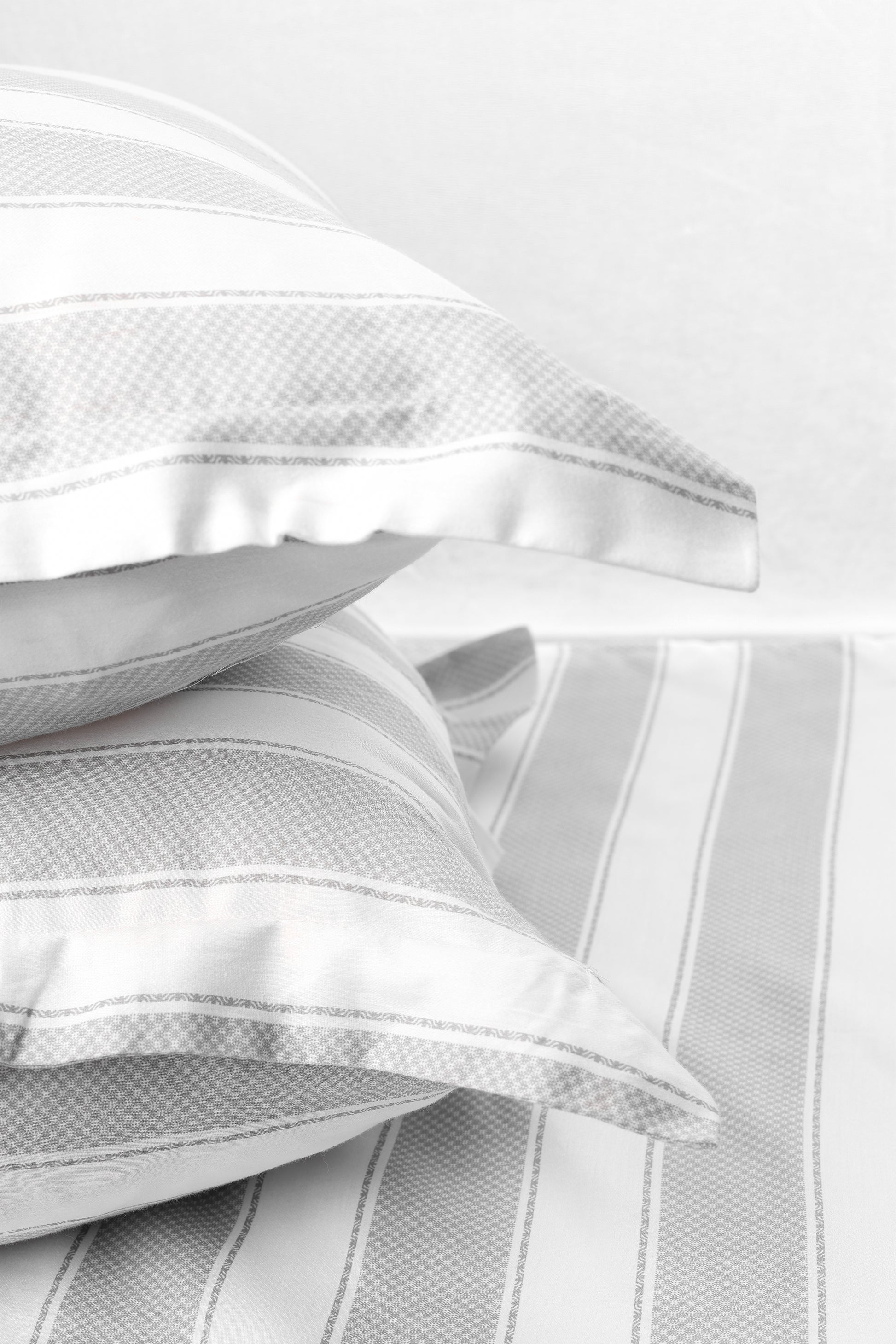 Stack of two white and grey pilows with pure cotton 400 tc double bed bedsheet in king size