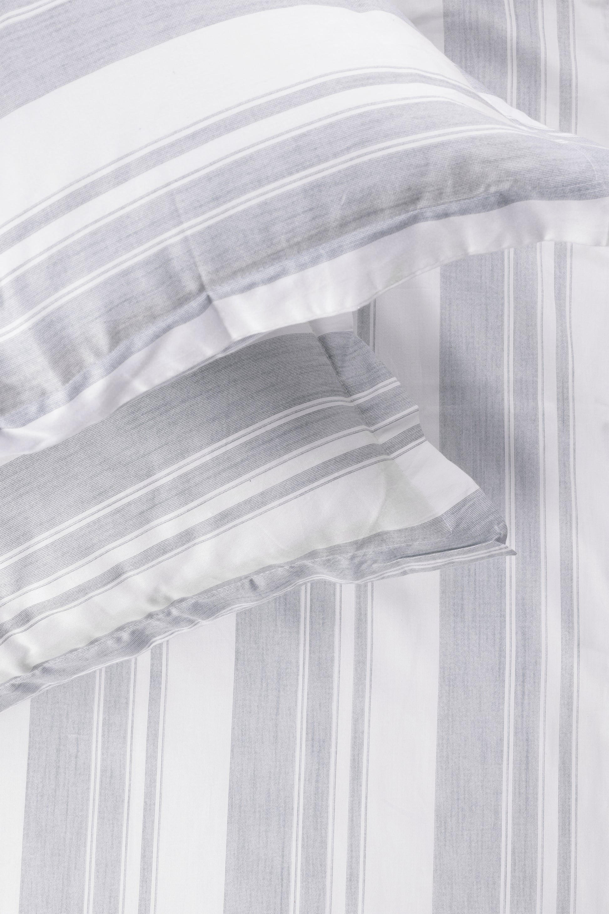 Close-up of a white and ash green double bed bedsheet with two matching pillow covers in pure cotton. Buy bedsheet online.