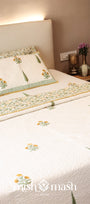 Bed with floral cotton bed cover and cotton pillows in a bedroom setting. bedspreads that make the perfect wedding gift.