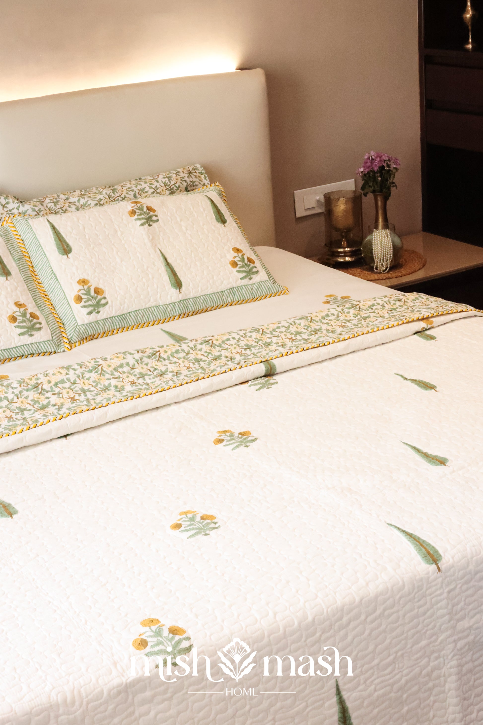 Bed with floral cotton bed cover and cotton pillows in a bedroom setting. bedspreads that make the perfect wedding gift.