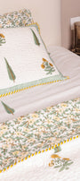 Floral patterned bedspread on a bed with decorative pillows and soft jaipur bedsheets.