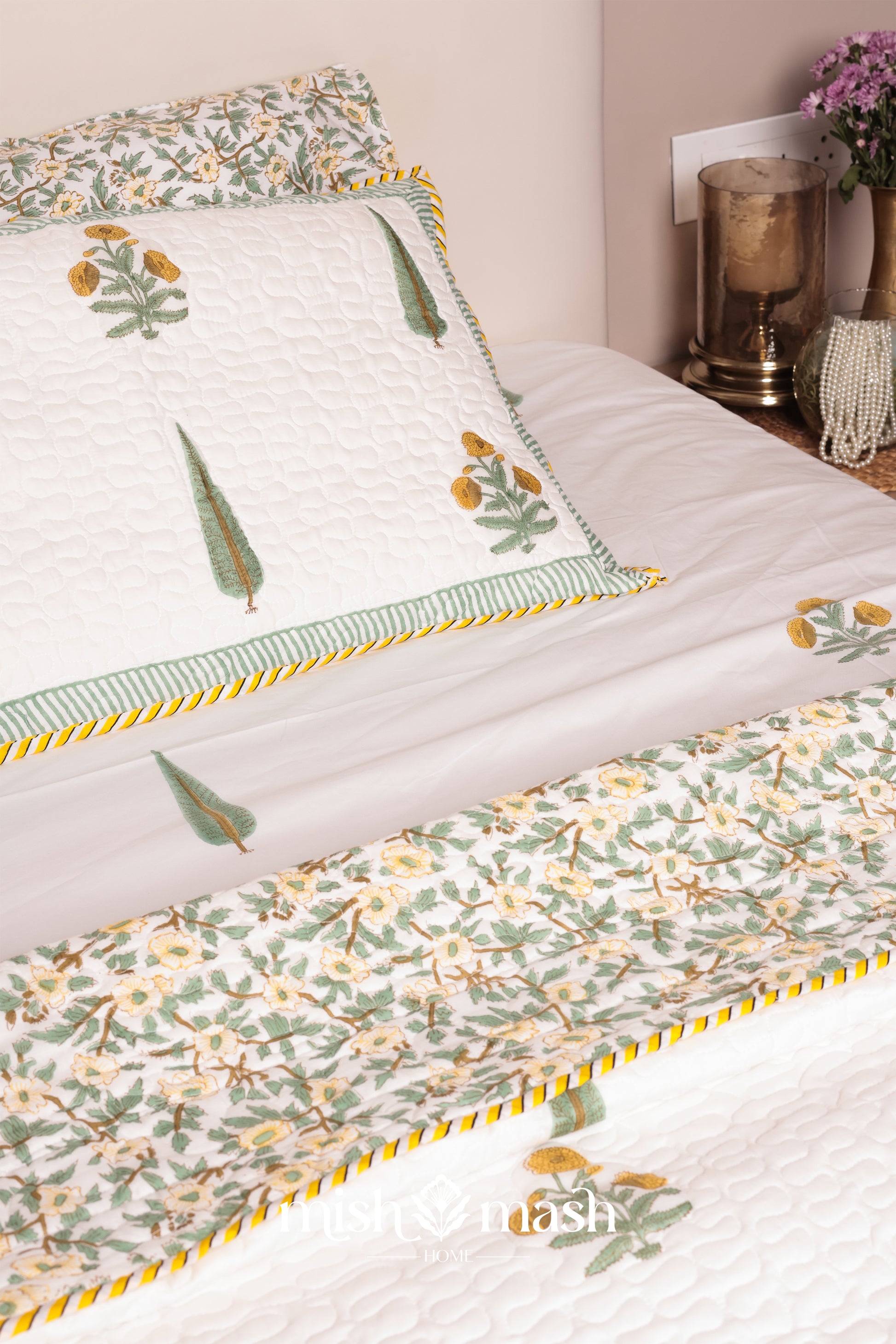 Floral patterned bedspread on a bed with decorative pillows and soft jaipur bedsheets.