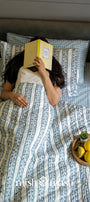 ac quilt with a woman lying on cotton bed sheet