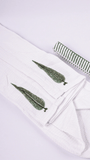 A folded white bathrobe with two green hand block printed leaf motifs