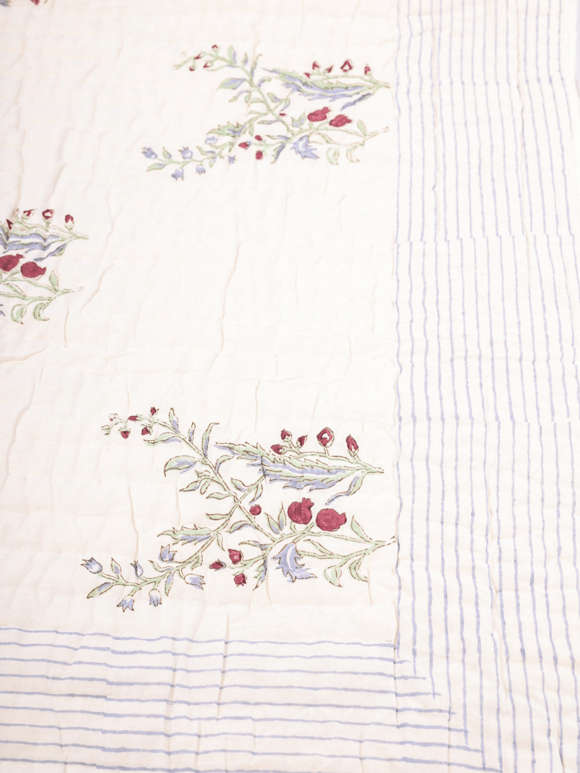 Hand block printed cotton quilt with green anar motifs