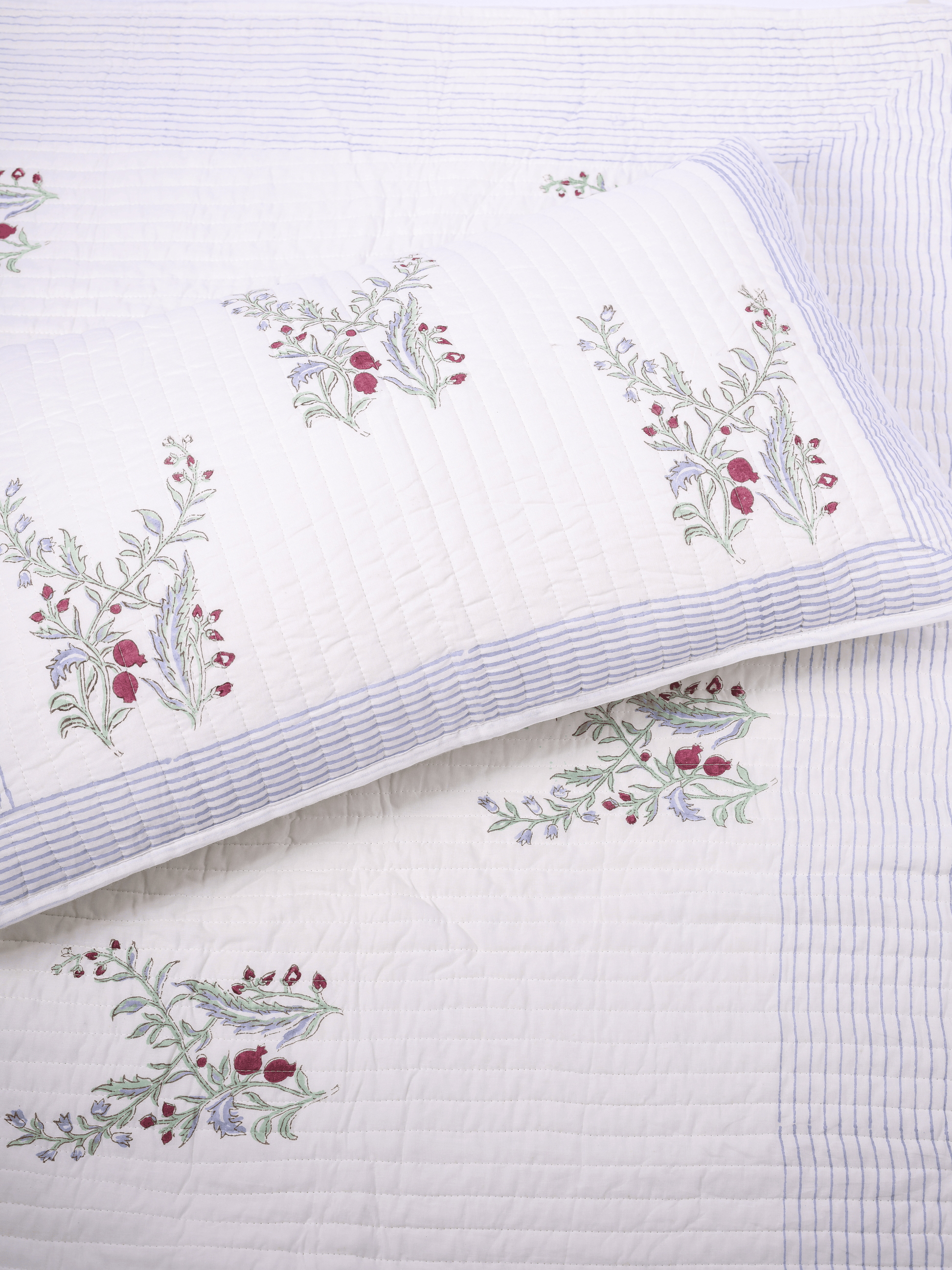 Handcrafted white bed cover with red and green pomegranate print